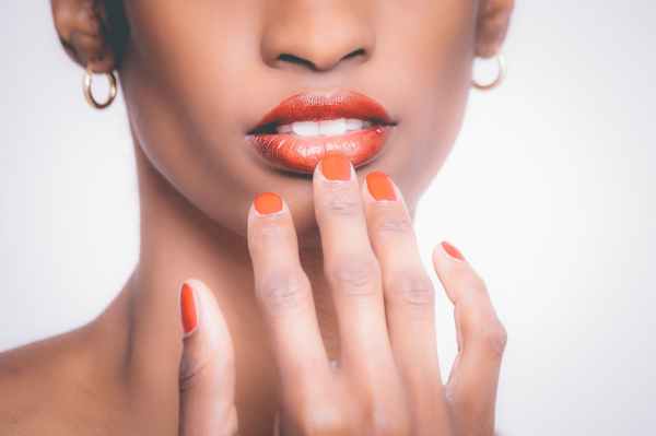 woman with orange manicure