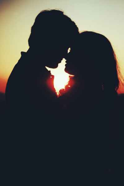 silhouette photo of man and woman about to kiss