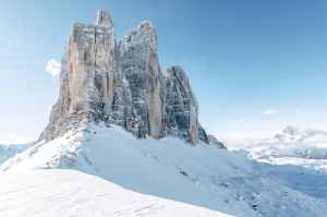 a rock mountain surrounded by snow covered ground